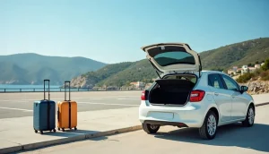Small white hire car with an open boot and two suitcases beside a sunny Greek island road